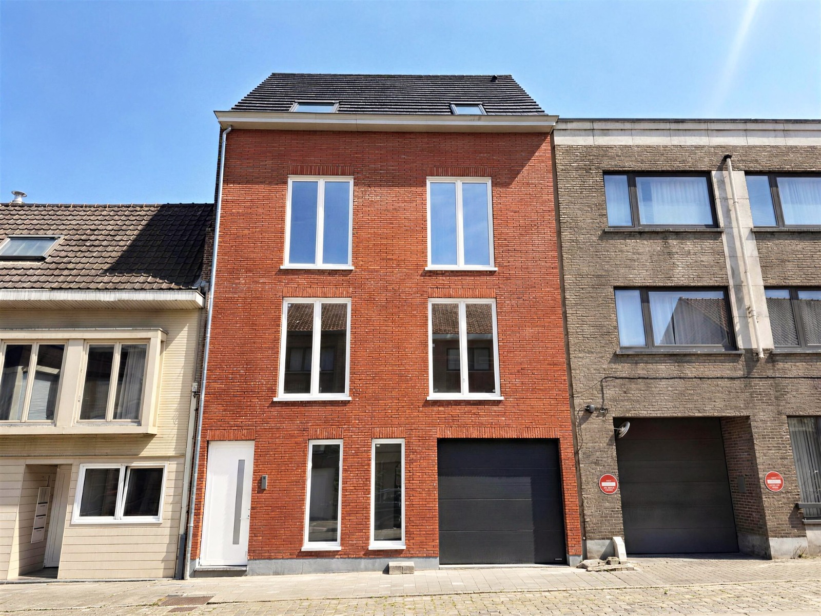 Maison contemporaine en briques rouges sous un ciel bleu