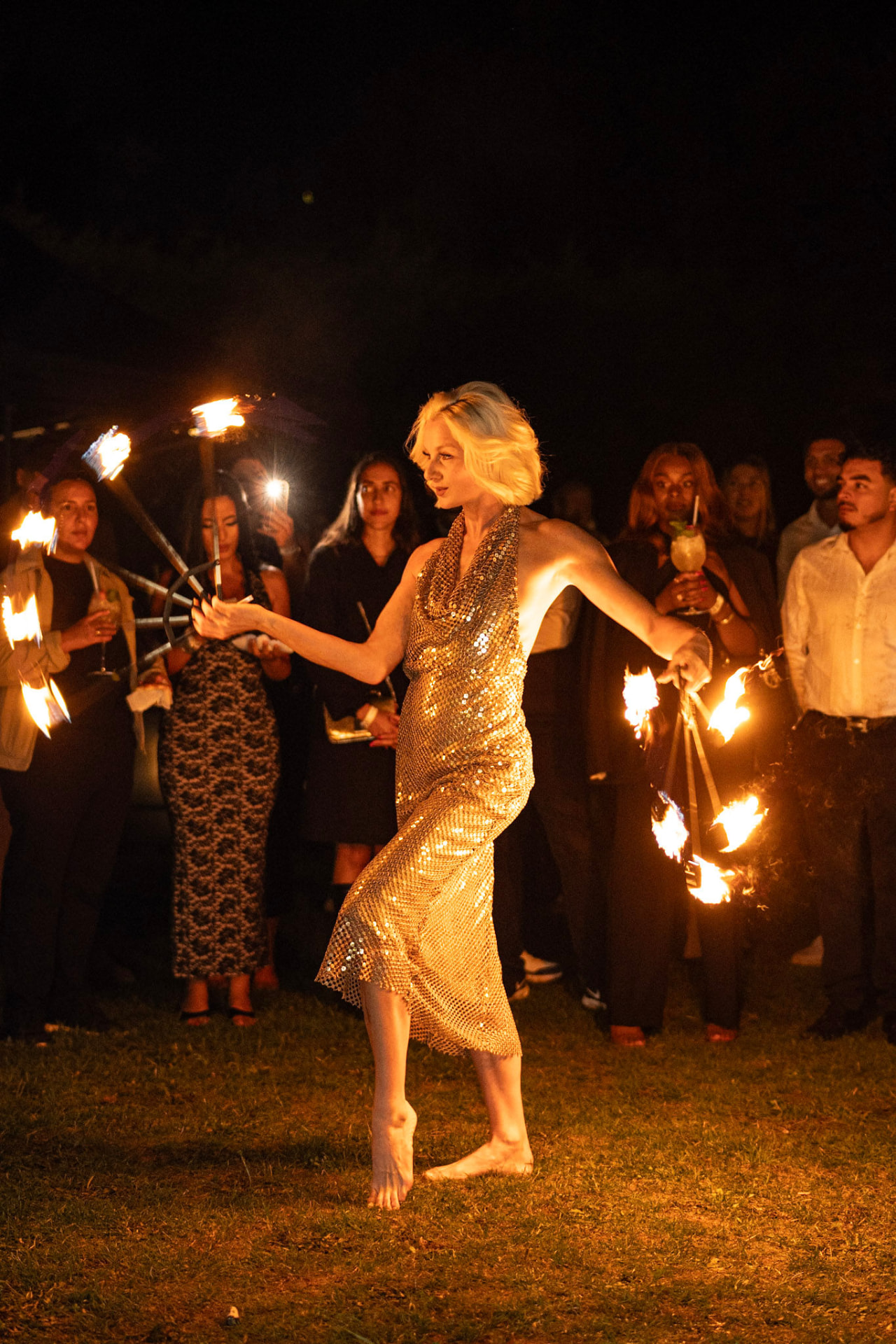 Danseuse de feu en robe dorée devant les invités lors d'une soirée du The Palace Event